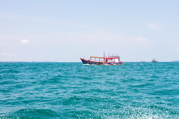 Obraz premium Boat floating for tourist or fishing in the tropical sea near island.