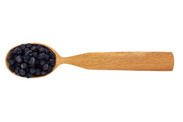 Dried Aronia melanocarpa or black mountain ash in a wooden spoon on a white background. Phytotherapy and disease prevention. Herbal collection for medicinal tinctures. Herbal tea in folk medicine