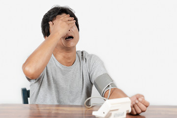 血圧測定の結果に落胆する中年男性