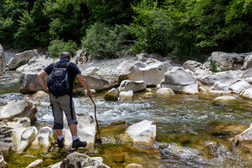 hiker standing in the water of a fiome in the gorges of the calore in Cilento