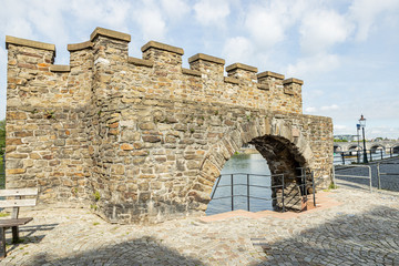 Medieval water gate known as Waterpoortje (Wyck) on the waterfront next the Maas river (Meuse), construction with its stone wall in the city of Maastricht, sunny day in South Limburg, Netherlands