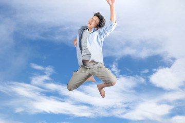 Fototapeta premium 青空バックに飛び上がる中年男性