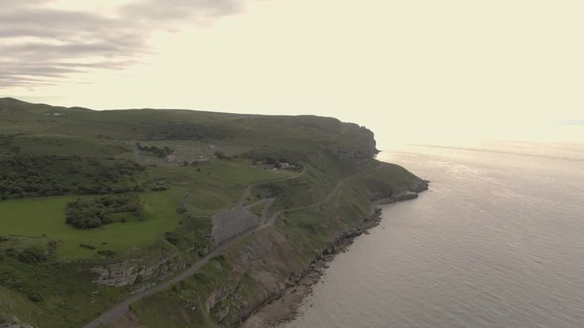 Aerial footage of scenic Great Orme, beautiful mountain cliff edge in coastal town Llandudno, North Wales near Snowdonia National Park. Mountain and Ocean View.  