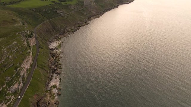 Aerial footage of scenic Great Orme, beautiful mountain cliff edge in coastal town Llandudno, North Wales near Snowdonia National Park. Mountain and Ocean View.  