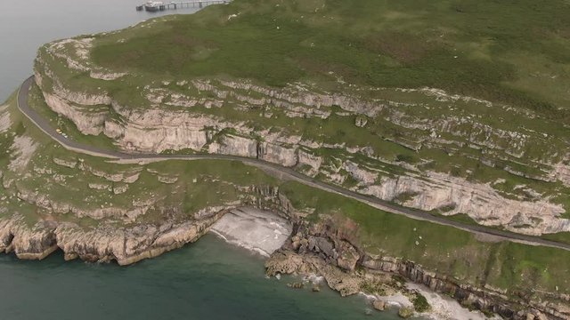 Aerial footage of scenic Great Orme, beautiful mountain cliff edge in coastal town Llandudno, North Wales near Snowdonia National Park. Mountain and Ocean View.  