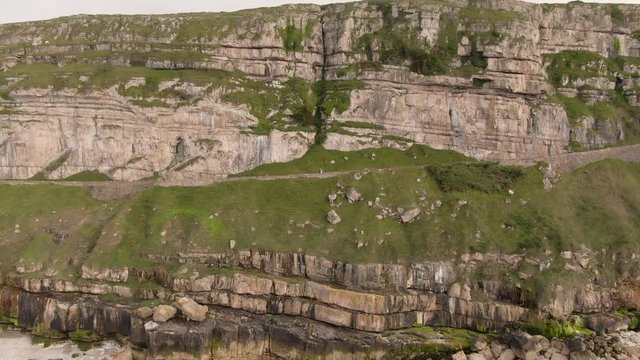 Aerial footage of scenic Great Orme, beautiful mountain cliff edge in coastal town Llandudno, North Wales near Snowdonia National Park. Mountain and Ocean View.  