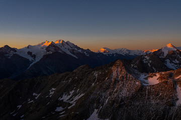 Die ersten Sonnenstrahlen am Gipfel der Berge im schönen Wallis in der Schweiz