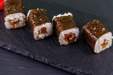 Sushi maki rolls with tuna on black slate