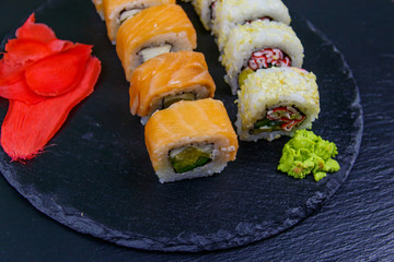 Set of sushi rolls on a black stone slate