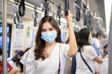 An young woman is wearing protective mask in metro , covid-19 protection , safety travel , new...
