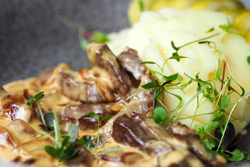 Beef stroganoff with mashed potatoes and pickled cucumbers, Russian dish