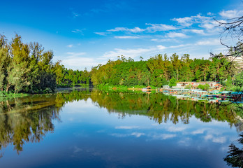 Fototapeta na wymiar lake pristine with green forest water reflection and bright blue sky at morning
