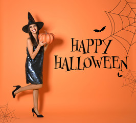 Happy Halloween greeting card design. Beautiful woman wearing witch costume with pumpkin on orange...