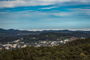 city view with mountain range and bright blue sky from hill top at day