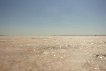 Close-up of sand on the beach of the salty pink lake Bursol (Altai Territory).