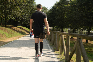 Man walking the park after playing sport