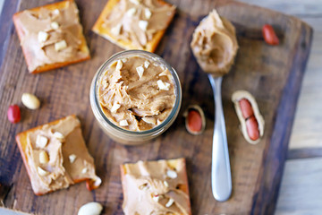 Fototapeta na wymiar Selective focus. Peanut butter on crackers. Peanuts. A jar of peanut butter. High-calorie breakfast. Delicious snack.