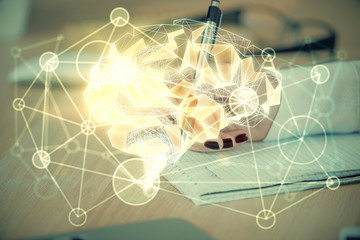 Multi exposure of woman's writing hand on background with brain hologram. Concept of brainstorming.