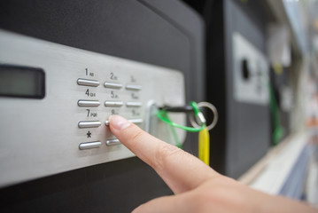 Woman enters the code from the safe close up.