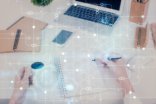 Double exposure of writing hand on background with data technology hologram. Big data concept.