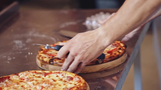 Chef cutting pizza. Chef cutting freshly prepared pizza
