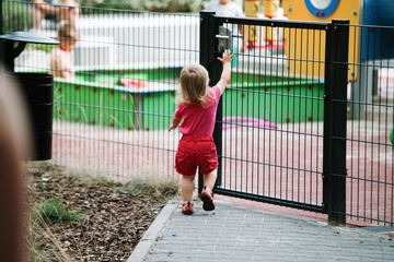 baby girl go to the child playground, open the door