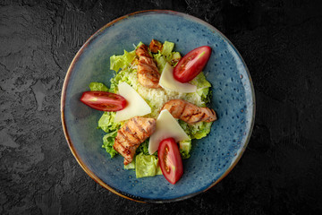 Grilled chicken fillet salad with lettuce, croutons, parmesan and fresh vegetables. Light balanced diet food