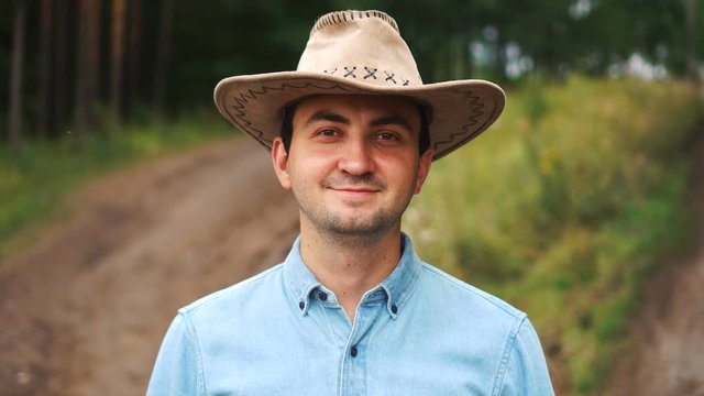 Young modern confident cowboy looking at camera in countryside