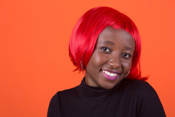 beautiful young african female with red hair on a red background