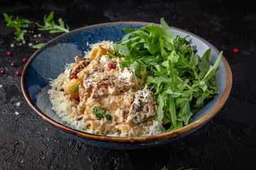Gourmet delicious penne pasta cooked with beef and cheese with arugula salad. Balanced nutritious dish. Still life for restaurant poster
