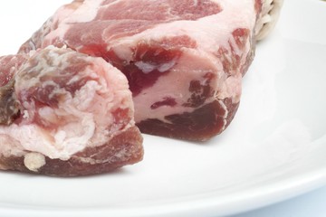 カットしたパンチェッタの塊と白い皿