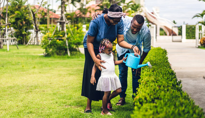 Fototapeta premium Portrait of enjoy happy love black family african american father and mother with little african girl child smiling and having fun moments good time in summer park at home