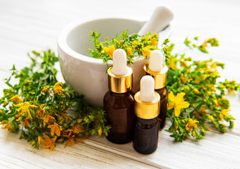 St johns wort oils, and  fresh herbs in a mortar