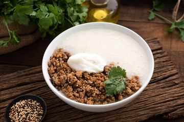 congee with pork and egg on wood food background 
