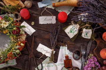 Still life on a wooden table. Lavender seeds, buds and flowers - aromatherapy and herbal medicine. Festive table in nature. Solstice concept. Lettering and Herbal Medicine and Aromatherapy.