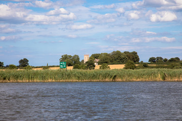 View of Saint Edmund Church in Thurne from the River Bure, The Broads, Norfolk, UK