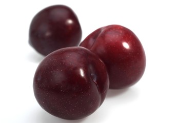 Red Plums against White Background