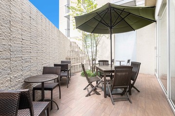 A set of wooden tables and chairs for relaxing in the garden outside the building