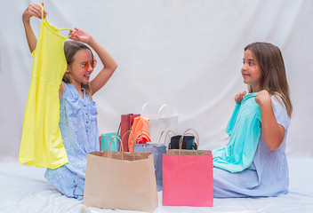 girls sort out shopping bags. Children show what they bought after shopping