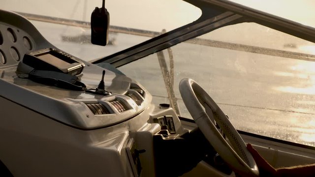 yacht with instruments and steering wheel at sunset and the hands of the captain