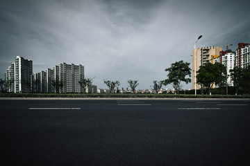   Clear sky, urban buildings, roads by dense woods