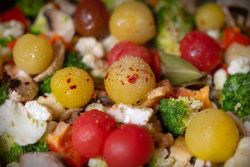 Ragout of vegetables with cauliflower, broccoli, paprika, cherry tomatoes in pan.