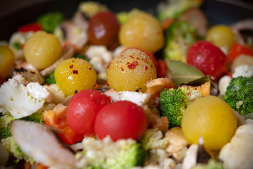 Ragout of vegetables with cauliflower, broccoli, paprika, cherry tomatoes in pan.