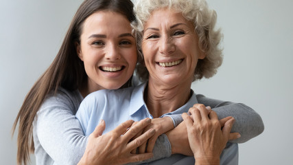 Head shot close up portrait of positive happy multigenerational female bonding family. Smiling...