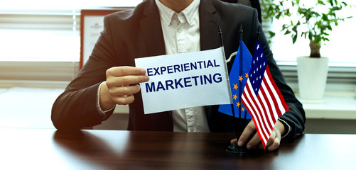 man take a flag with text Experiential Marketing with flags on the office background