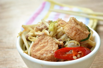 fried bean sprout with slice egg tofu and chop pork in cup on table
