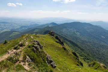 Fototapeta na wymiar Summer landscape of the Carpathians on a sunny day. The main watershed. Mount Pikuy, Ukraine. Rock ledges on a background of mountains. Landscape with high mountains.