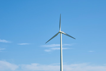 Fototapeta premium Wind turbine against blue sky. Wind power energy concept