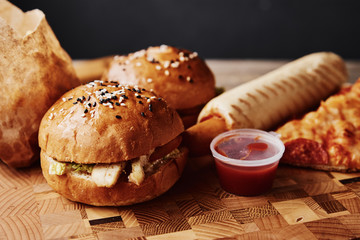 Unhealthy and junk food. Different types of fastfood and snacks on the table, closeup. Takeaway food
