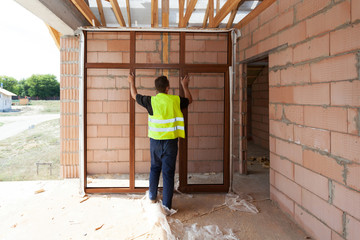Man holding plastic frame, installing new pvc window